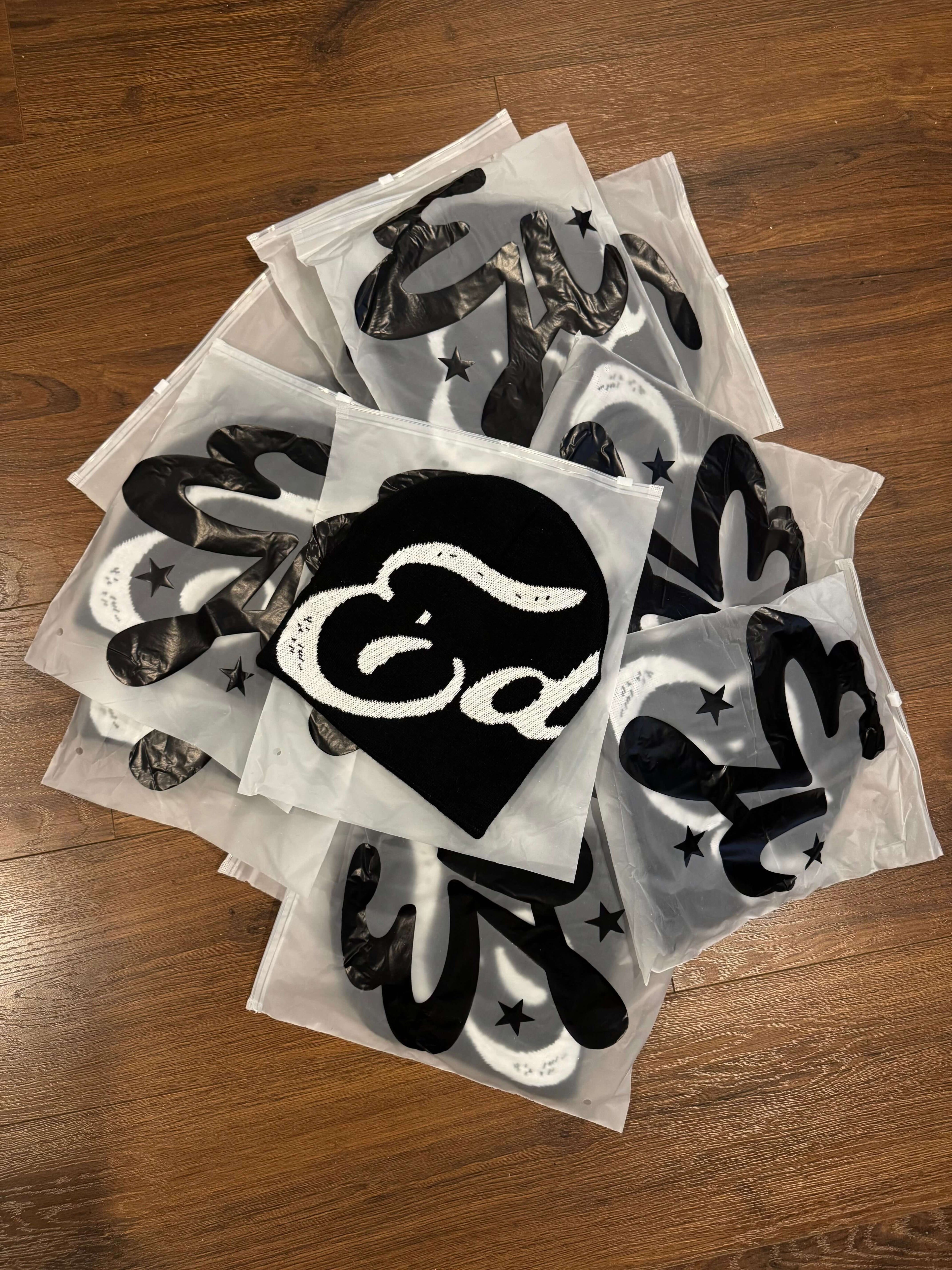 A collection of packaged EDEN Cursive Beanie designs featuring unique prints and branding.